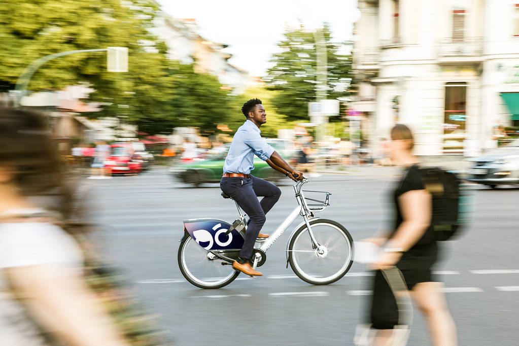 Ein Mann fährt auf einem öffentlichen Fahrrad in der Stadt.